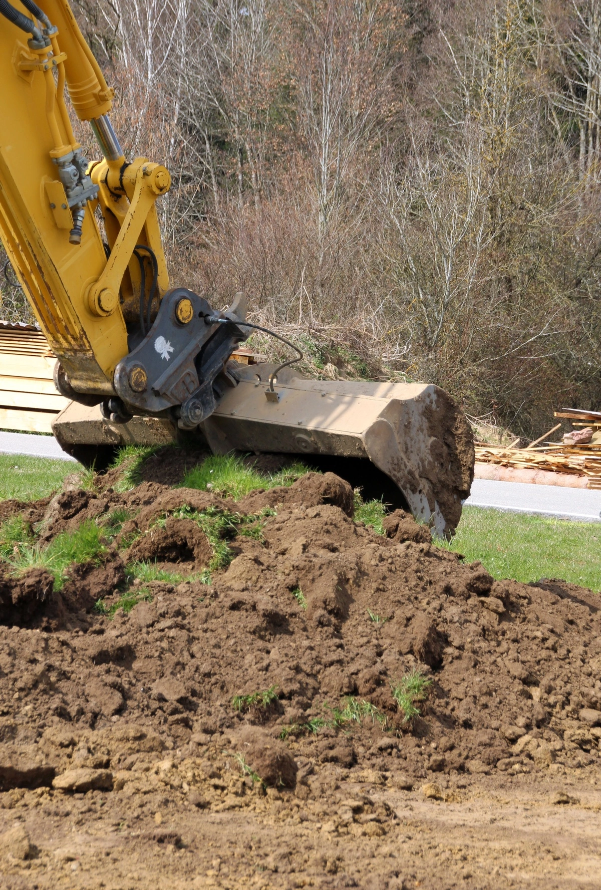 Pelleteuse creusant la terre pour des travaux de terrassement, illustrant la préparation du terrain